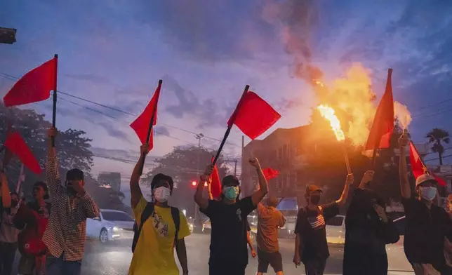 Pro-democracy protesters hold torches and flags during a flash mob rally to protest against Myanmar's military-government in Yangon, Myanmar on Sept.19, 2024. (Anti-Junta Alliance Yangon via AP)