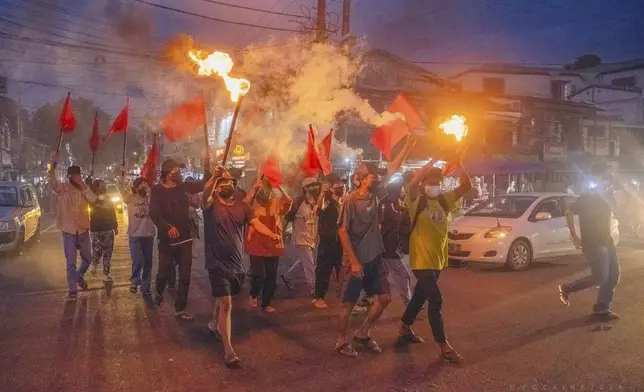 Pro-democracy protesters hold torches and flags during a flash mob rally to protest against Myanmar's military-government in Yangon, Myanmar on Sept.19, 2024. (Anti-Junta Alliance Yangon via AP)