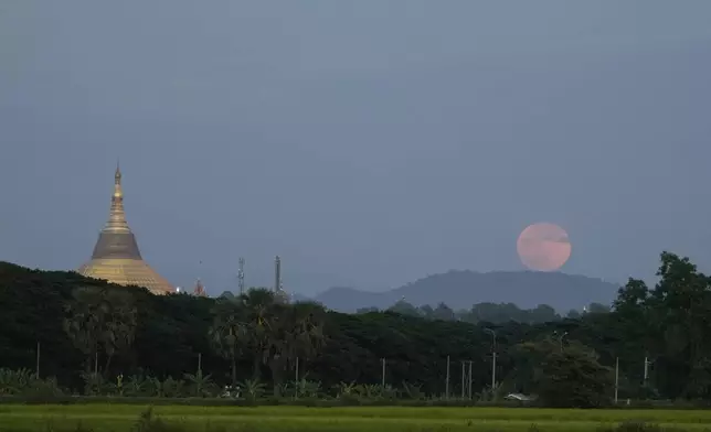 The moon rises beside the Uppatasanti Pagoda seen from Naypyitaw, Myanmar, Thursday, Oct. 17, 2024. (AP Photo/Aung Shine Oo)