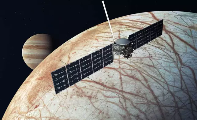 This illustration provided by NASA depicts the Europa Clipper spacecraft over the moon, Europa, with Jupiter at background left. (NASA/JPL-Caltech via AP)