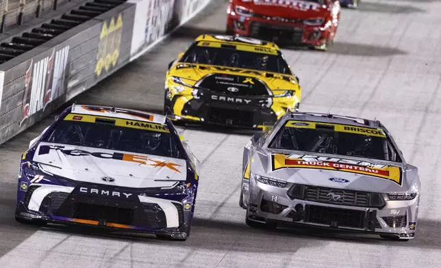 Denny Hamlin (11) leads Chase Briscoe (14) and Christopher Bell (20) during a NASCAR Cup Series auto race, Saturday, Sept. 21, 2024, in Bristol, Tenn. (AP Photo/Wade Payne)