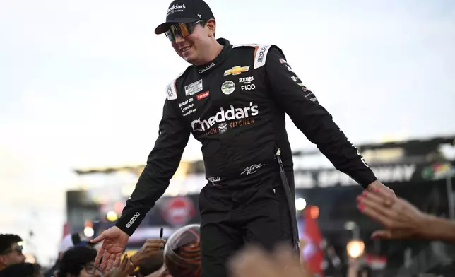 FILE - Kyle Busch interacts with spectators while walking down a runway during driver introductions before a NASCAR Cup Series auto race at Daytona International Speedway, Aug. 24, 2024, in Daytona Beach, Fla. (AP Photo/Phelan M. Ebenhack, File)