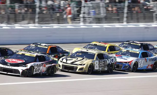 Christopher Bell (20), Kyle Busch (8), William Byron (24), Tyler Reddick (45), Joey Logano (22) and Ryan Blaney (12) head down the front straightaway after a caution flag during a NASCAR Cup Series auto race at Kansas Speedway in Kansas City, Kan., Sunday, Sept. 29, 2024. (AP Photo/Colin E. Braley)