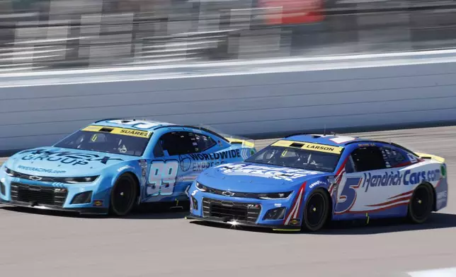 Daniel Suarez (99) and Kyle Larson (5) head down the front straightaway during a NASCAR Cup Series auto race at Kansas Speedway in Kansas City, Kan., Sunday, Sept. 29, 2024. (AP Photo/Colin E. Braley)