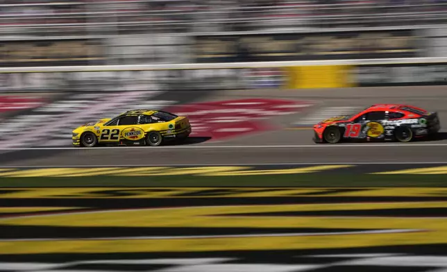 NASCAR Cup Series drivers Joey Logano (22) and Martin Truex Jr. (19) race during a NASCAR Cup Series auto race Sunday, Oct. 20, 2024, in Las Vegas. (AP Photo/John Locher)