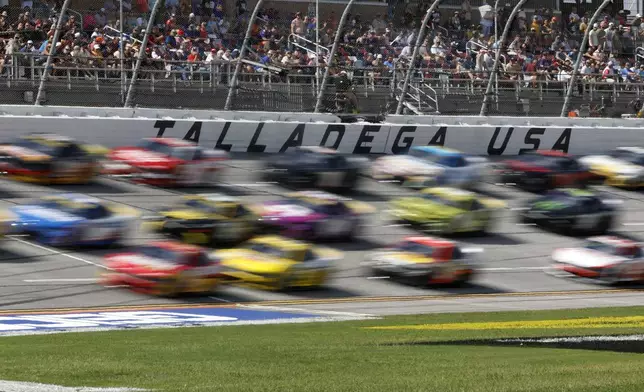 Drivers race down the front stretch three wide during a NASCAR Cup Series auto race at Talladega Superspeedway, Sunday, Oct. 6, 2024, in Talladega, Ala. (AP Photo/ Butch Dill)