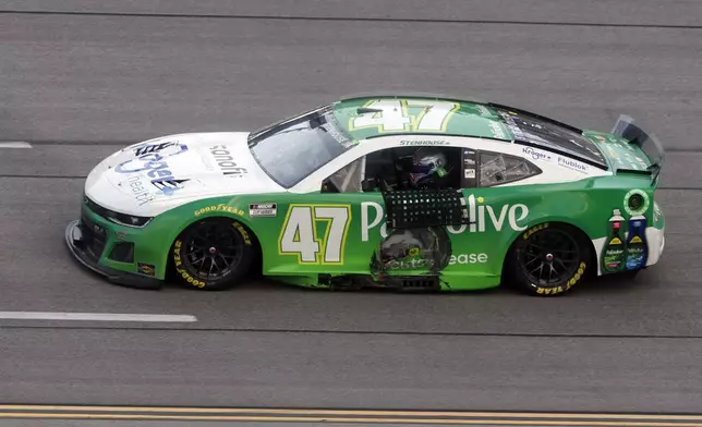 Driver Ricky Stenhouse Jr. drives by the grand stands after winning a NASCAR Cup Series auto race at Talladega Superspeedway, Sunday, Oct. 6, 2024, in Talladega, Ala. (AP Photo/ Butch Dill)