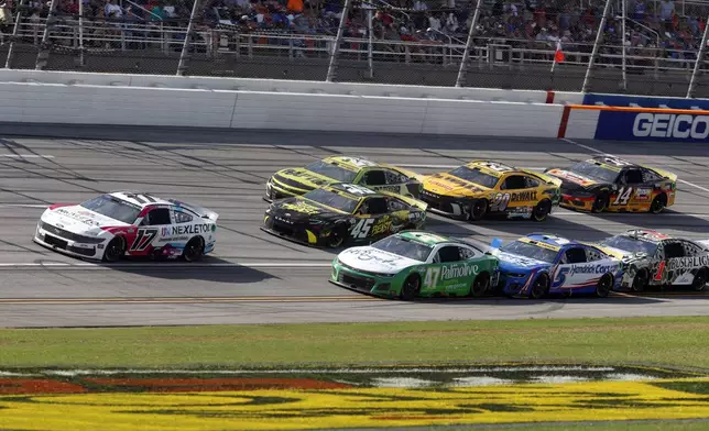 Driver Chris Buescher (17) leads a pack of cars to the end of Stage One during a NASCAR Cup Series auto race at Talladega Superspeedway, Sunday, Oct. 6, 2024, in Talladega, Ala. (AP Photo/ Butch Dill)