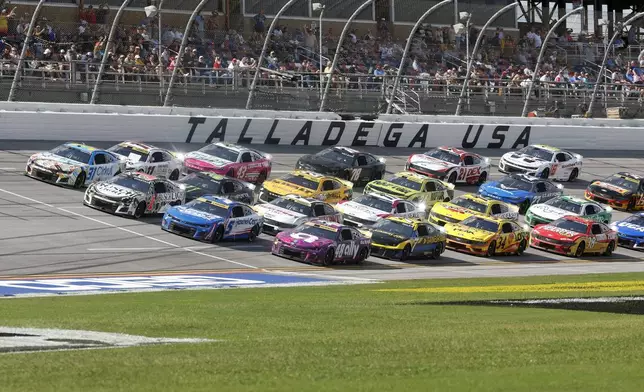 Drivers race down the front stretch four wide during a NASCAR Cup Series auto race at Talladega Superspeedway, Sunday, Oct. 6, 2024, in Talladega, Ala. (AP Photo/ Butch Dill)