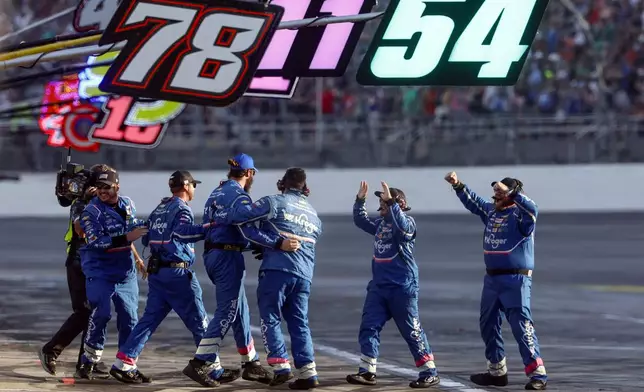 Driver Ricky Stenhouse Jr.'s pit crew celebrates after the win during a NASCAR Cup Series auto race at Talladega Superspeedway, Sunday, Oct. 6, 2024, in Talladega, Ala. (AP Photo/ Butch Dill)