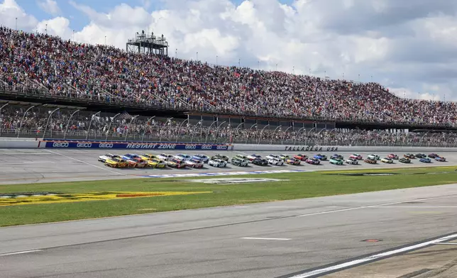 Driver Michael McDowell (34) leads the pack to the start of a NASCAR Cup Series auto race at Talladega Superspeedway, Sunday, Oct. 6, 2024, in Talladega, Ala. (AP Photo/ Butch Dill)