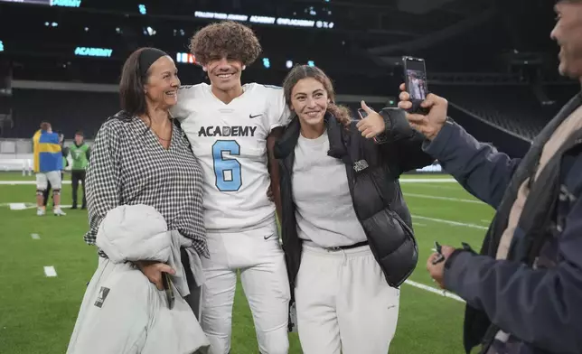 NFL Academy player Rafael Varona Blackstad, second left, poses with his family after a football game between the NFL Academy team and De La Salle High School, Tuesday, Oct. 8, 2024, in London. (AP Photo/Kin Cheung)