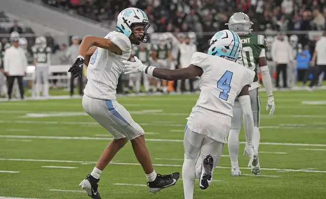 NFL Academy player Rafael Varona Blackstad, left, celebrates during a football game between the NFL Academy team and De La Salle High School, Tuesday, Oct. 8, 2024, in London. (AP Photo/Kin Cheung)