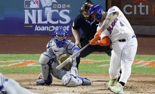 New York Mets' Francisco Alvarez hits a RBI-single against the Los Angeles Dodgers during the third inning in Game 5 of a baseball NL Championship Series, Friday, Oct. 18, 2024, in New York. (AP Photo/Adam Hunger)