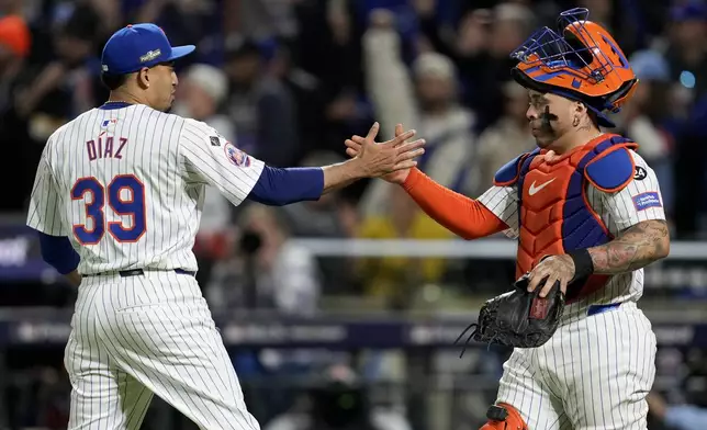 New York Mets pitcher Edwin Díaz and catcher Francisco Alvarez celebrates their win against the Los Angeles Dodgers in Game 5 of a baseball NL Championship Series, Friday, Oct. 18, 2024, in New York. (AP Photo/Ashley Landis)