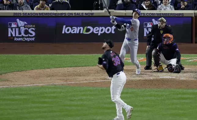 Los Angeles Dodgers' Shohei Ohtani watches his three-run home run against the New York Mets during the eighth inning in Game 3 of a baseball NL Championship Series, Wednesday, Oct. 16, 2024, in New York. (AP Photo/Adam Hunger)