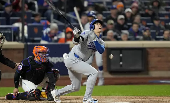 Los Angeles Dodgers' Shohei Ohtani reacts after getting hit by a foul ball against the New York Mets during the sixth inning in Game 3 of a baseball NL Championship Series, Wednesday, Oct. 16, 2024, in New York. (AP Photo/Ashley Landis)