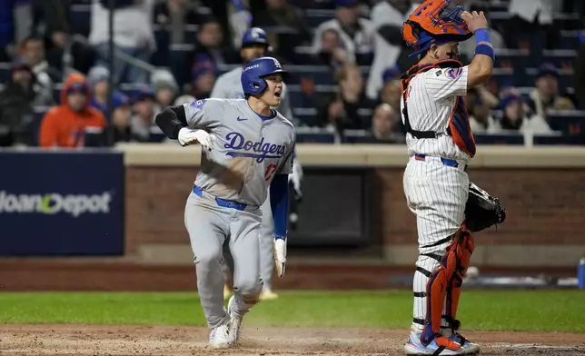 Los Angeles Dodgers' Shohei Ohtani scores past New York Mets catcher Francisco Alvarez on a double by Mookie Betts during the fourth inning in Game 4 of a baseball NL Championship Series, Thursday, Oct. 17, 2024, in New York. (AP Photo/Ashley Landis)