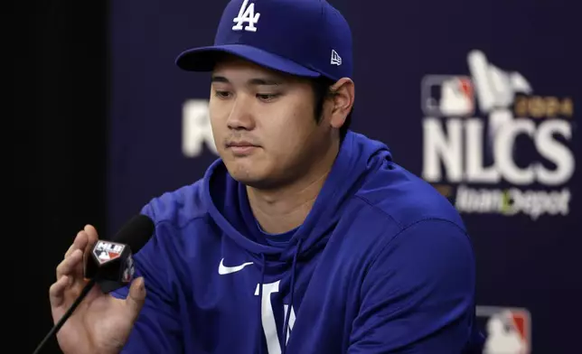 Los Angeles Dodgers' Shohei Ohtani adjusts his microphone as he talks to the media Tuesday, Oct. 15, 2024, in New York ahead of Game 3 of the baseball NL Championship Series against the New York Mets. (AP Photo/Adam Hunger)