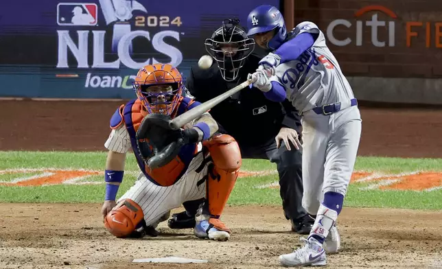 Los Angeles Dodgers' Mookie Betts hits a two-run home run against the New York Mets during the sixth inning in Game 4 of a baseball NL Championship Series, Thursday, Oct. 17, 2024, in New York (AP Photo/Adam Hunger)