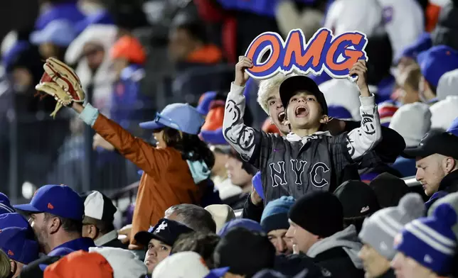 Fans cheer during the second inning in Game 3 of a baseball NL Championship Series between the Los Angeles Dodgers and the New York Mets, Wednesday, Oct. 16, 2024, in New York. (AP Photo/Adam Hunger)