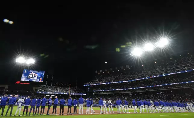 The New York Mets line up for introductions before Game 3 of a baseball NL Championship Series against the Los Angeles Dodgers, Wednesday, Oct. 16, 2024, in New York. (AP Photo/Frank Franklin II)