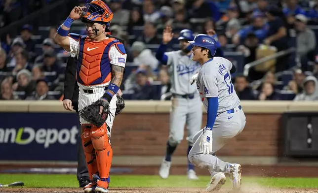 Los Angeles Dodgers' Shohei Ohtani scores past New York Mets catcher Francisco Alvarez on a double by Mookie Betts during the fourth inning in Game 4 of a baseball NL Championship Series, Thursday, Oct. 17, 2024, in New York. (AP Photo/Frank Franklin II)