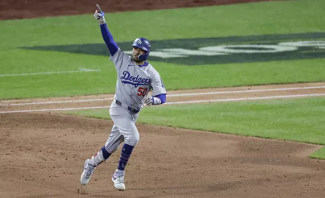 Los Angeles Dodgers' Mookie Betts celebrates a home run against the New York Mets during the sixth inning in Game 5 of a baseball NL Championship Series, Friday, Oct. 18, 2024, in New York. (AP Photo/Adam Hunger)