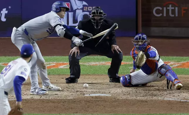 Los Angeles Dodgers' Shohei Ohtani breaks his bat and grounds out against the New York Mets during the seventh inning in Game 4 of a baseball NL Championship Series, Thursday, Oct. 17, 2024, in New York. (AP Photo/Adam Hunger)