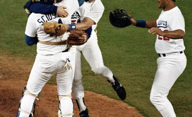 FILE - Los Angeles Dodgers Mike Scioscia, left, and Steve Sax congratulate pitcher Orel Hershiser, center, after shutting out the New York Mets to win the National League Championship Series in Los Angeles, Oct. 12, 1988. Teammate Franklin Stubbs joins them at right. (AP Photo/Lennox McLendon, File)