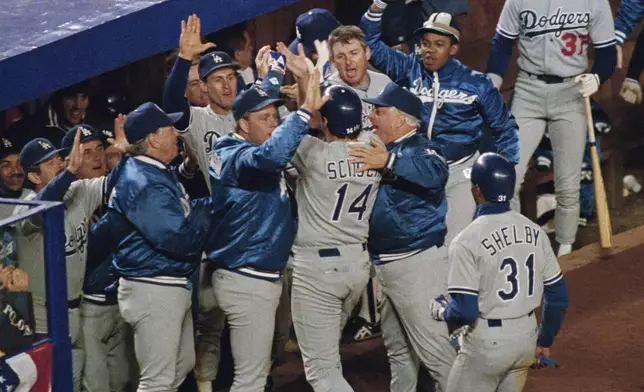 FILE - Los Angeles Dodgers batter Mike Scioscia (14) is greeted by his teammates and manager Tommy Lasorda after his two-run homer in the ninth inning in Game 4 of the National League Championship Series against the New York Mets in New York, Oct. 9, 1988. (AP Photo/Lou Requena, File)