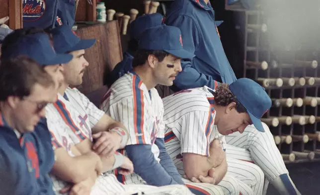 FILE - New York Mets Wally Backman, center left, and Gary Carter, right, sit dejectedly in the dugout at the end of their National League playoff game with the Los Angeles Dodgers at New York, Oct. 10, 1988. (AP Photo/Ray Stubblebine, File)