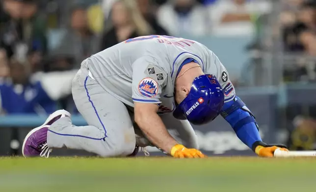 New York Mets' Pete Alonso reacts after getting hit with a foul ball against the Los Angeles Dodgers during the eighth inning in Game 6 of a baseball NL Championship Series, Sunday, Oct. 20, 2024, in Los Angeles. (AP Photo/Julio Cortez)