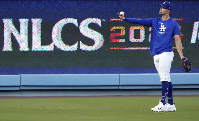 Los Angeles Dodgers starting pitcher Jack Flaherty poses momentarily before throwing in the outfield during practice in preparation for Game 1 of a baseball NL Championship Series against the New York Mets, Saturday, Oct. 12, 2024, in Los Angeles. (AP Photo/Mark J. Terrill)