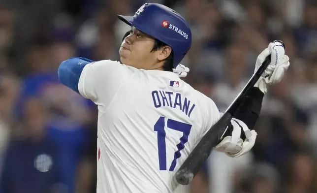 Los Angeles Dodgers' Shohei Ohtani hits RBI-single against the New York Mets during the sixth inning in Game 6 of a baseball NL Championship Series, Sunday, Oct. 20, 2024, in Los Angeles. (AP Photo/Ashley Landis)