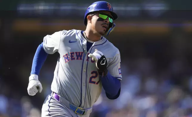 New York Mets' Mark Vientos runs to first base after a single during the fourth inning in Game 2 of a baseball NL Championship Series against the Los Angeles Dodgers, Monday, Oct. 14, 2024, in Los Angeles. (AP Photo/Ashley Landis)