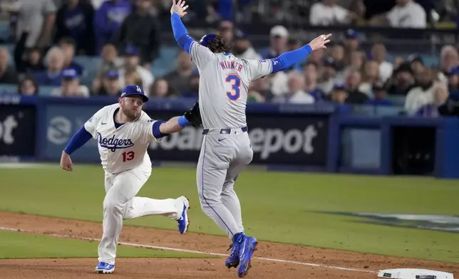 Los Angeles Dodgers third baseman Max Muncy tags out New York Mets' Jesse Winker at third base after a single by Jose Iglesias during the fifth inning in Game 1 of a baseball NL Championship Series, Sunday, Oct. 13, 2024, in Los Angeles. (AP Photo/Mark J. Terrill)