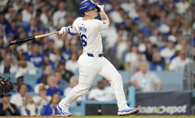 Los Angeles Dodgers' Will Smith watches his two-run home run against the New York Mets during the third inning in Game 6 of a baseball NL Championship Series, Sunday, Oct. 20, 2024, in Los Angeles. (AP Photo/Julio Cortez)