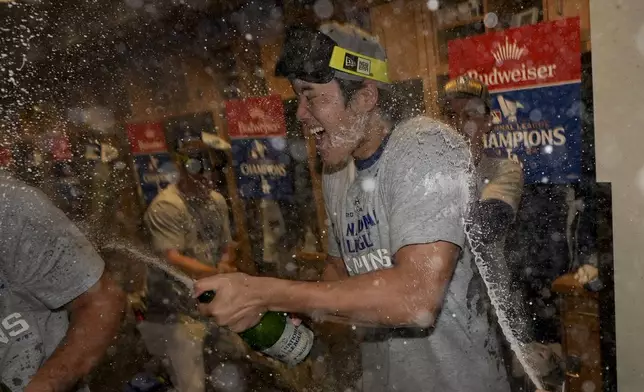 Los Angeles Dodgers Shohei Ohtani celebrates in the locker room after their win against the New York Mets in Game 6 of a baseball NL Championship Series, Sunday, Oct. 20, 2024, in Los Angeles. The Dodgers will face the New York Yankees in the World (AP Photo/Ashley Landis)