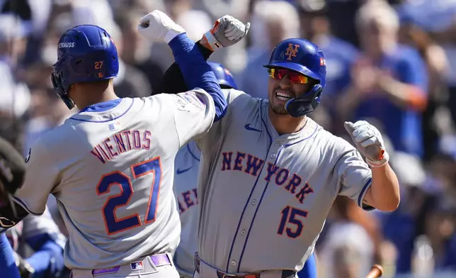 New York Mets' Mark Vientos, left, celebrates after a grand slam home run with Tyrone Taylor against the Los Angeles Dodgers during the second inning in Game 2 of a baseball NL Championship Series, Monday, Oct. 14, 2024, in Los Angeles. (AP Photo/Gregory Bull)