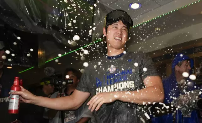 Los Angeles Dodgers Yoshinobu Yamamoto celebrates in the locker room after their win against the New York Mets in Game 6 of a baseball NL Championship Series, Sunday, Oct. 20, 2024, in Los Angeles. The Dodgers will face the New York Yankees in the World Series. (AP Photo/Ashley Landis)