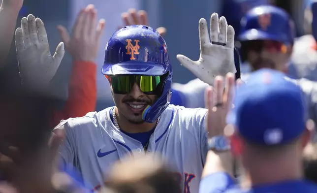 New York Mets' Mark Vientos celebrates in the dugout after his grand slam home run against the Los Angeles Dodgers during the second inning in Game 2 of a baseball NL Championship Series, Monday, Oct. 14, 2024, in Los Angeles. (AP Photo/Ashley Landis)