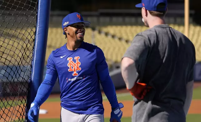 New York Mets' Francisco Lindor, left, smiles after batting during practice in preparation for Game 6 in a baseball NL Championship Series against the Los Angeles Dodgers, Saturday, Oct. 19, 2024, in Los Angeles. (AP Photo/Mark J. Terrill)