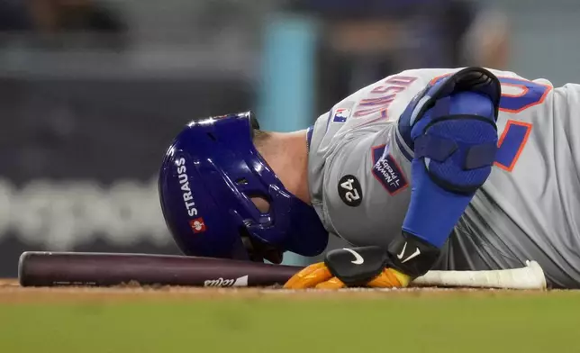 New York Mets' Pete Alonso reacts after getting hit with a foul ball against the Los Angeles Dodgers during the eighth inning in Game 6 of a baseball NL Championship Series, Sunday, Oct. 20, 2024, in Los Angeles. (AP Photo/Ashley Landis)