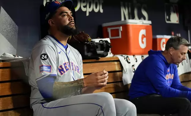 New York Mets pitcher Sean Manaea sits in the dugout after leaving the game against the Los Angeles Dodgers in Game 6 of a baseball NL Championship Series, Sunday, Oct. 20, 2024, in Los Angeles. (AP Photo/Julio Cortez)