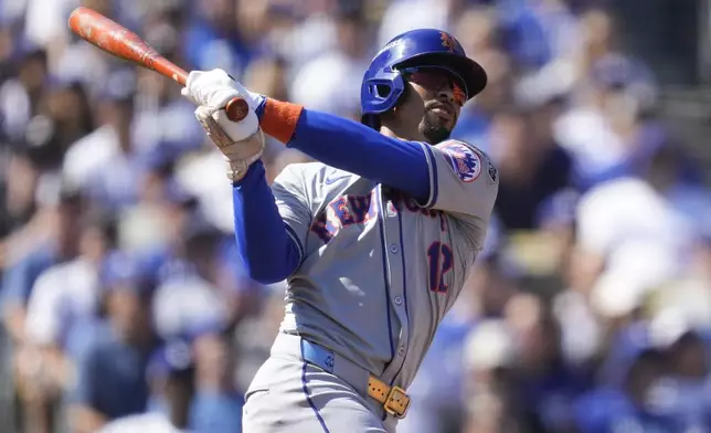 New York Mets' Francisco Lindor follows through as he hits a solo home run against the Los Angeles Dodgers during the first inning in Game 2 of a baseball NL Championship Series, Monday, Oct. 14, 2024, in Los Angeles. (AP Photo/Ashley Landis)