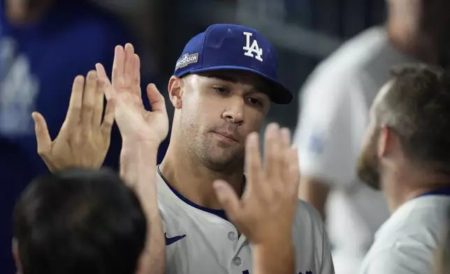 Los Angeles Dodgers pitcher Jack Flaherty is high-fived in the dugout in the seventh inning in Game 1 of a baseball NL Championship Series against the New York Mets, Sunday, Oct. 13, 2024, in Los Angeles. (AP Photo/Ashley Landis)