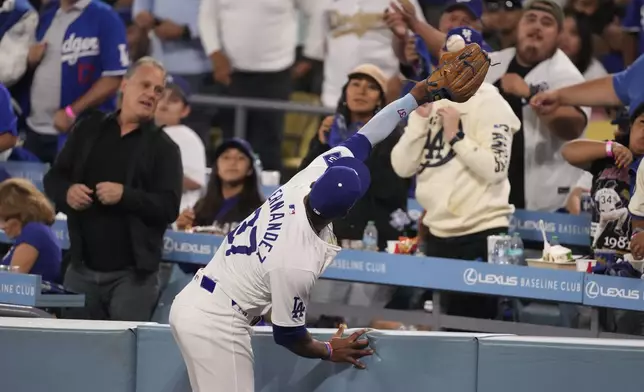 Los Angeles Dodgers left fielder Teoscar Hernández catches a fly ball hit by New York Mets' Brandon Nimmo during the sixth inning in Game 1 of a baseball NL Championship Series, Sunday, Oct. 13, 2024, in Los Angeles. (AP Photo/Mark J. Terrill)