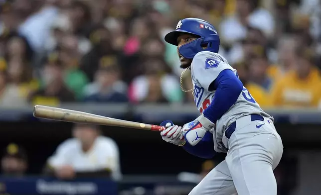 Los Angeles Dodgers' Mookie Betts watches his solo home run during the first inning in Game 3 of a baseball NL Division Series against the San Diego Padres, Tuesday, Oct. 8, 2024, in San Diego. (AP Photo/Gregory Bull)