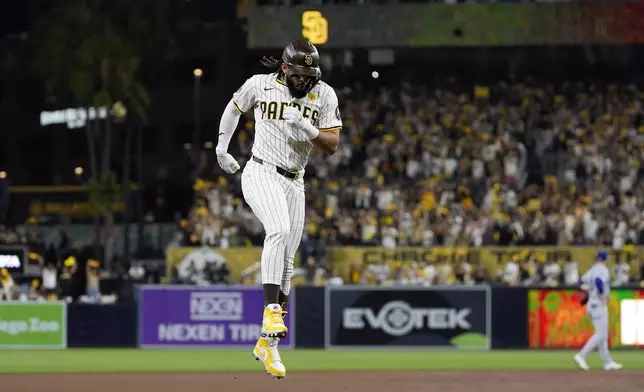 San Diego Padres' Fernando Tatis Jr. hops around third base after hitting a two-run home run during the second inning in Game 3 of a baseball NL Division Series against the Los Angeles Dodgers, Tuesday, Oct. 8, 2024, in San Diego. (AP Photo/Gregory Bull)